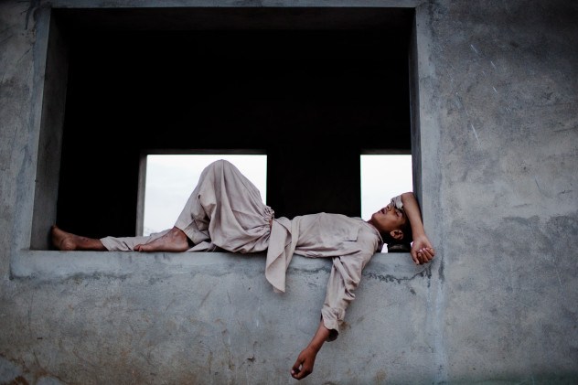 RAWALPINDI, PAKISTAN - AUGUST 04: A boy sleeps on a wall at a bus station during 'Iftar', when Muslims break their fast, on the third day of the holy month of Ramadan on August 4, 2011 in Rawalpindi, Pakistan. Ramadan, the month in which the holy Quran was revealed to the prophet Mohammad, is observed by devout Muslims who abstain from food, drink and sex from dawn until sunset, when they break the fast with the meal known as Iftar. (Photo by Daniel Berehulak/Getty Images)